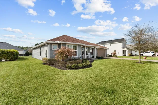 a view of a house with a big yard plants and large trees