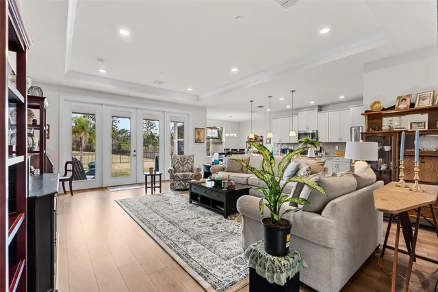 a living room with furniture kitchen view and large windows