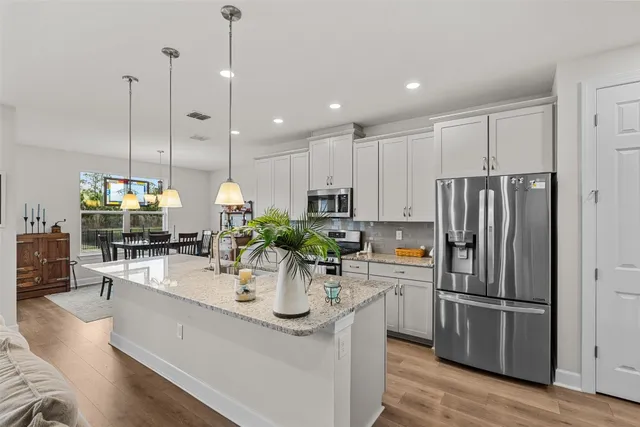 a kitchen with stainless steel appliances granite countertop a sink a stove and refrigerator