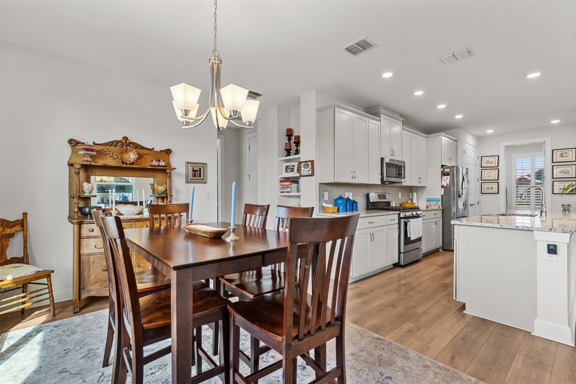 93322 Sandown Drive Fernandina Beach, FL 32034 - Photo 26 of 40 a view of a dining room and a kitchen island with furniture and wooden floor