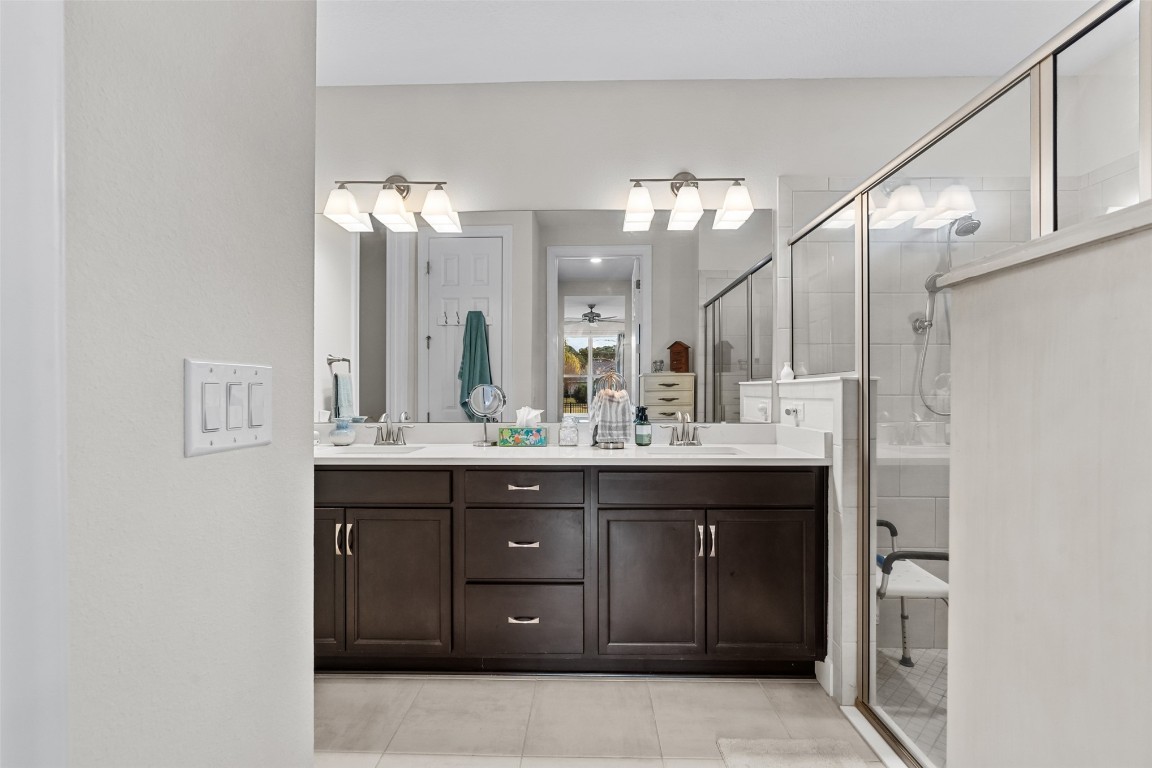 93322 Sandown Drive Fernandina Beach, FL 32034 - Photo 29 of 40 a bathroom with a granite countertop sink a mirror and a shower