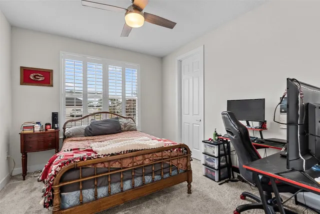a bedroom with a bed and a flat tv screen on the dresser