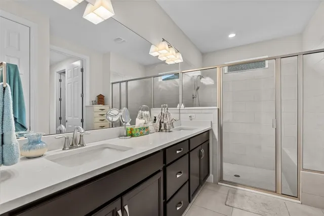 a bathroom with a double vanity sink mirror and shower