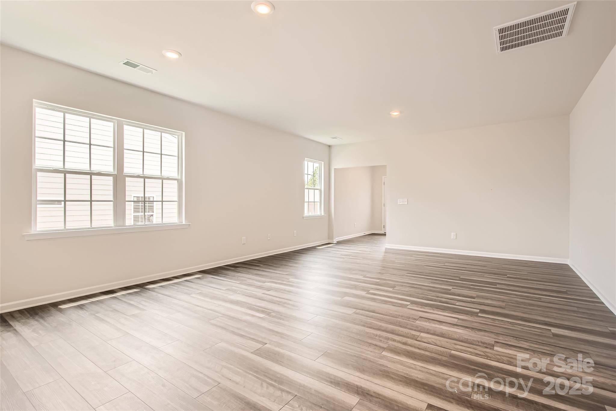8473 Norman Frst Road Lancaster, SC 29720 - Photo 5 of 18 an empty room with wooden floor and windows