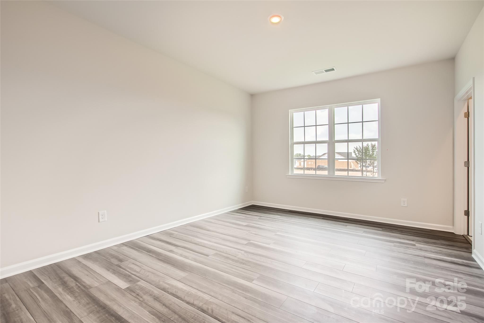 8473 Norman Frst Road Lancaster, SC 29720 - Photo 7 of 18 an empty room with wooden floor and windows