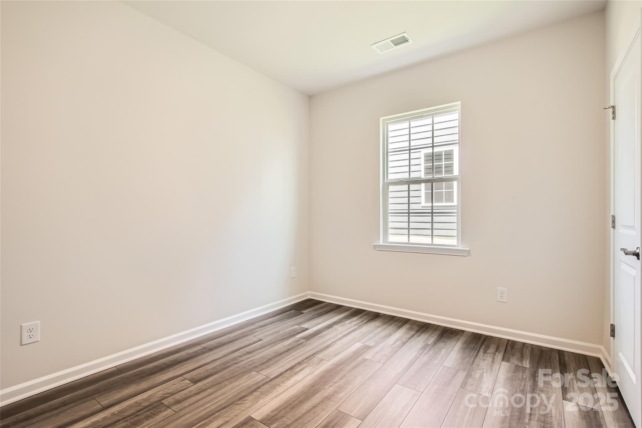 8473 Norman Frst Road Lancaster, SC 29720 - Photo 10 of 18 an empty room with wooden floor and windows