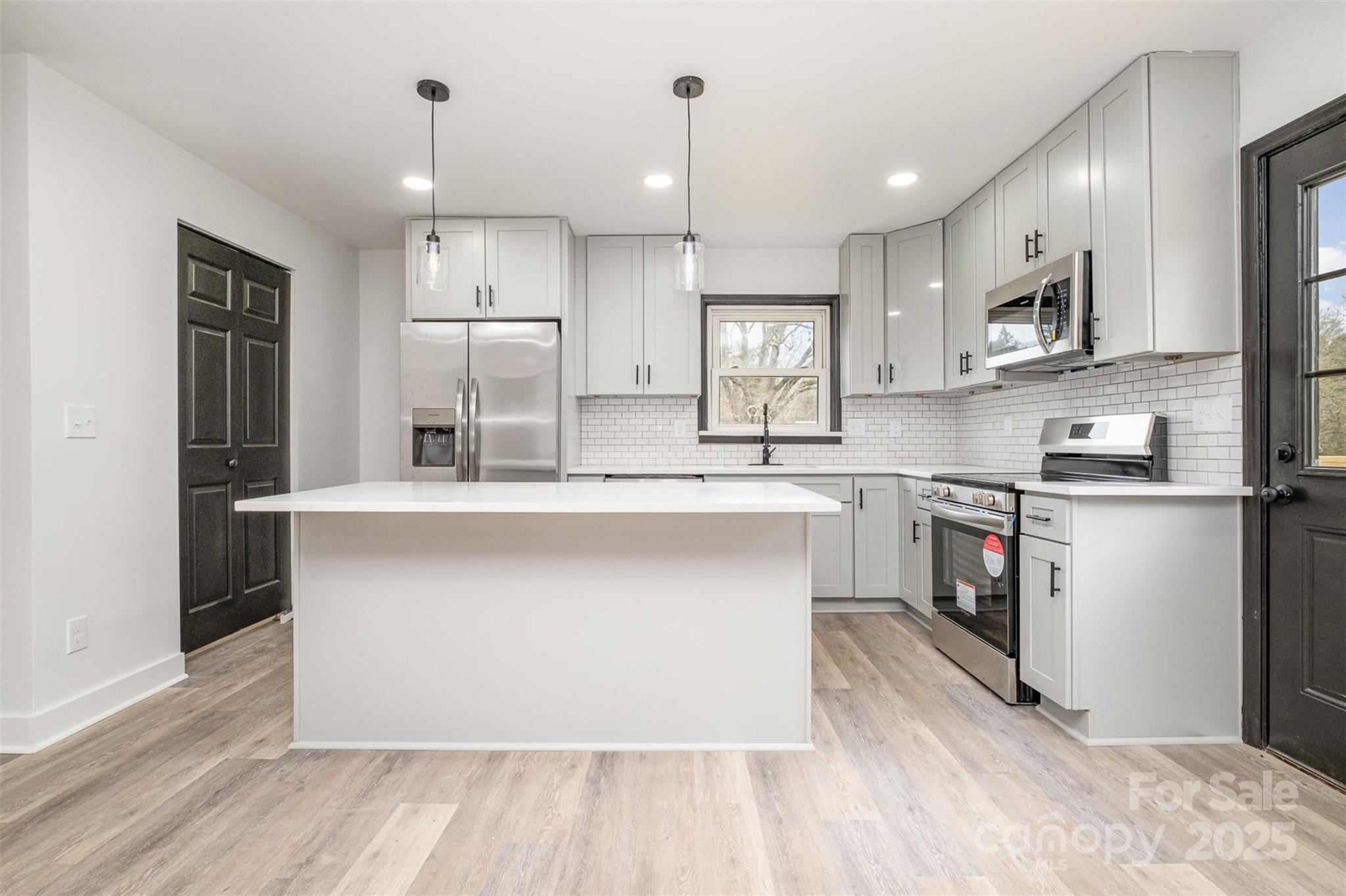 5674 Alan D Good Lane Conover, NC 28613 - Photo 8 of 21 a kitchen with stainless steel appliances granite countertop a refrigerator a sink dishwasher a stove and white countertops with wooden floor
