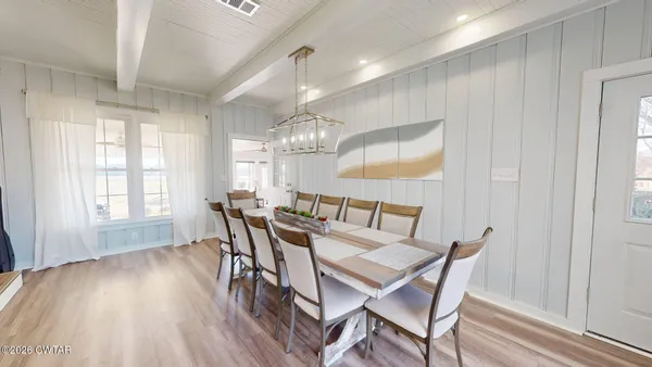 a view of a dining room with furniture a chandelier and wooden floor