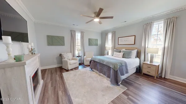 a bedroom with a large bed a large window and potted plant on the dresser