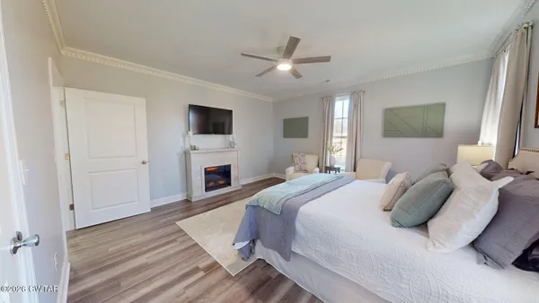 a spacious bedroom with a bed and a flat screen tv