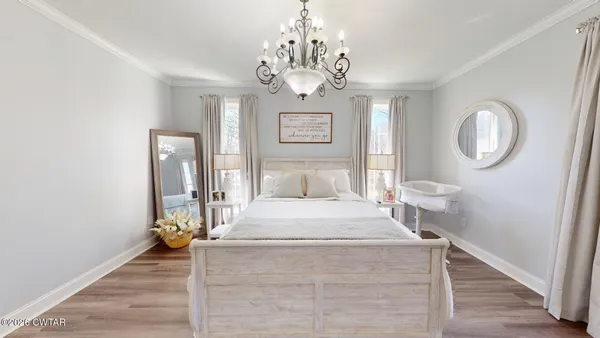 a bedroom with a bed and a chandelier