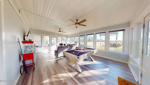 a living room with furniture a flat screen tv and a floor to ceiling window