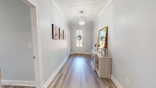 a view of a hallway with wooden floor and staircase