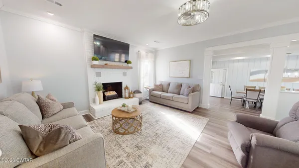 a living room with furniture a fireplace and a chandelier