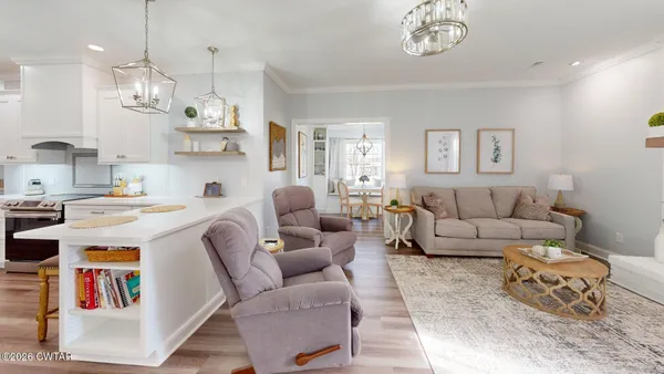 a living room with furniture kitchen and a table