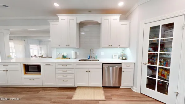 a kitchen with stainless steel appliances granite countertop a stove and white cabinets