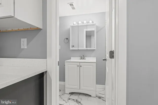a bathroom with a sink vanity and mirror