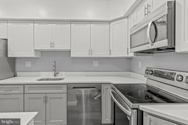 a kitchen with granite countertop white cabinets and a stove top oven