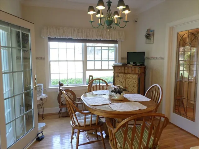 a view of a dining room with furniture a chandelier and window