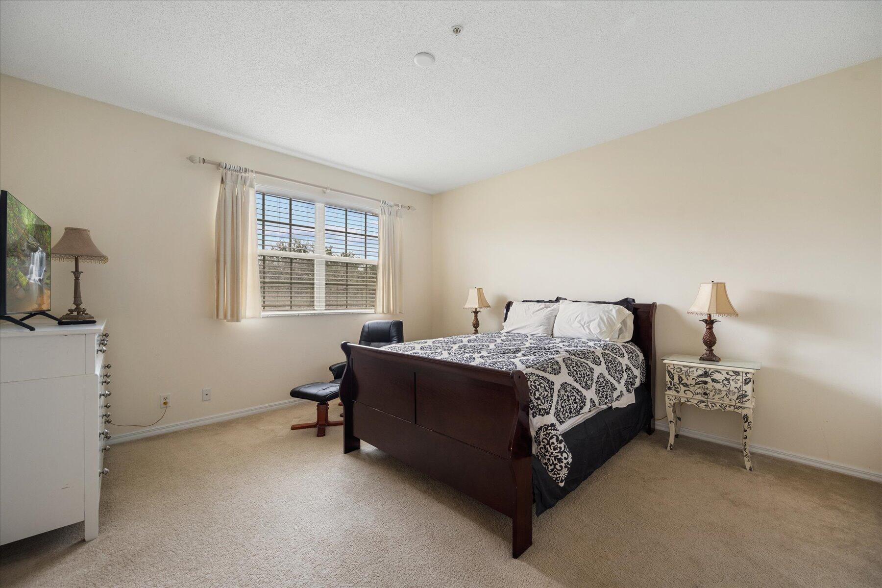 112 Lighthouse Circle, Unit G Tequesta, FL 33469 - Photo 15 of 27 a bed sitting in a bedroom next to a window