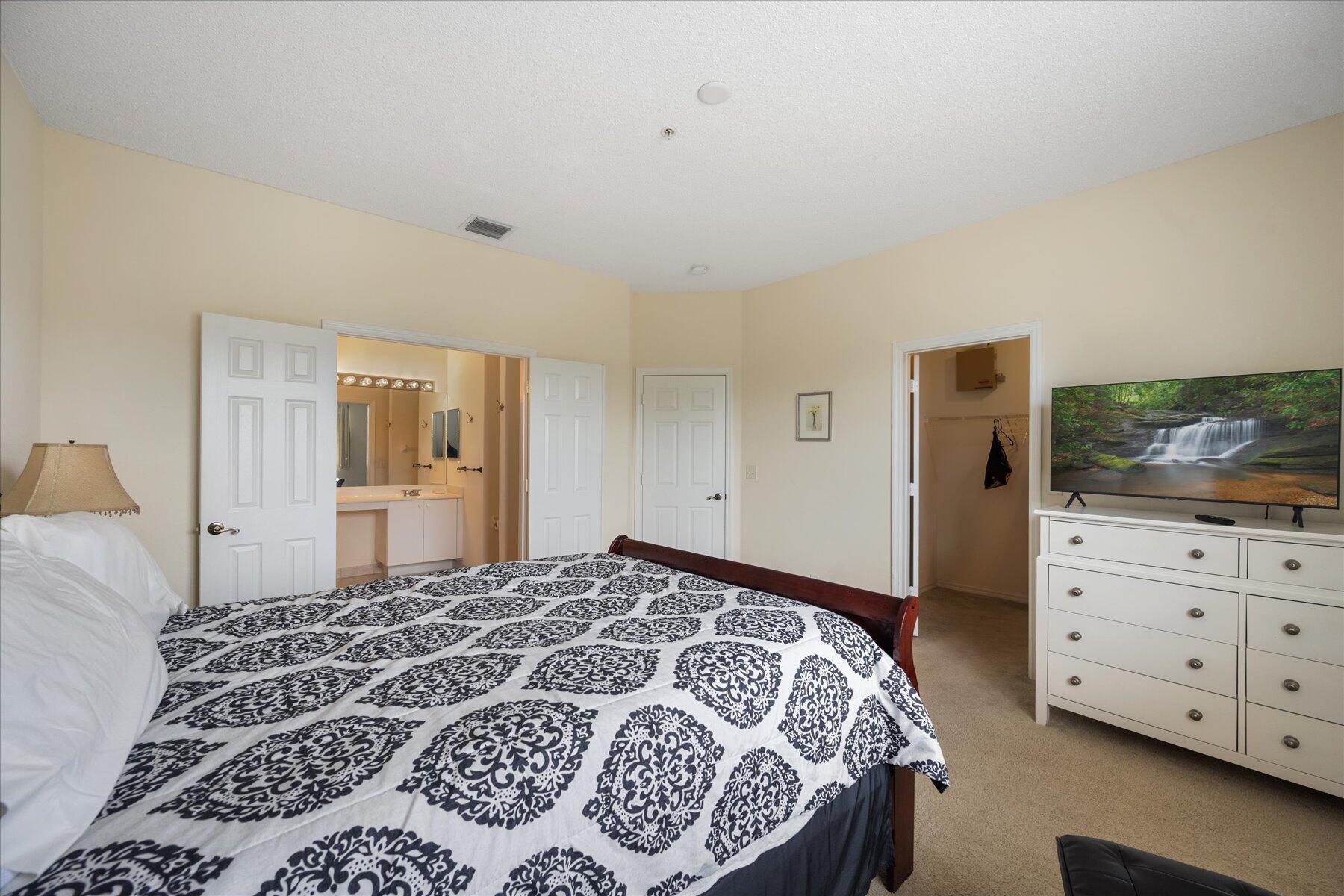 112 Lighthouse Circle, Unit G Tequesta, FL 33469 - Photo 16 of 27 a bedroom with a bed and a television in it
