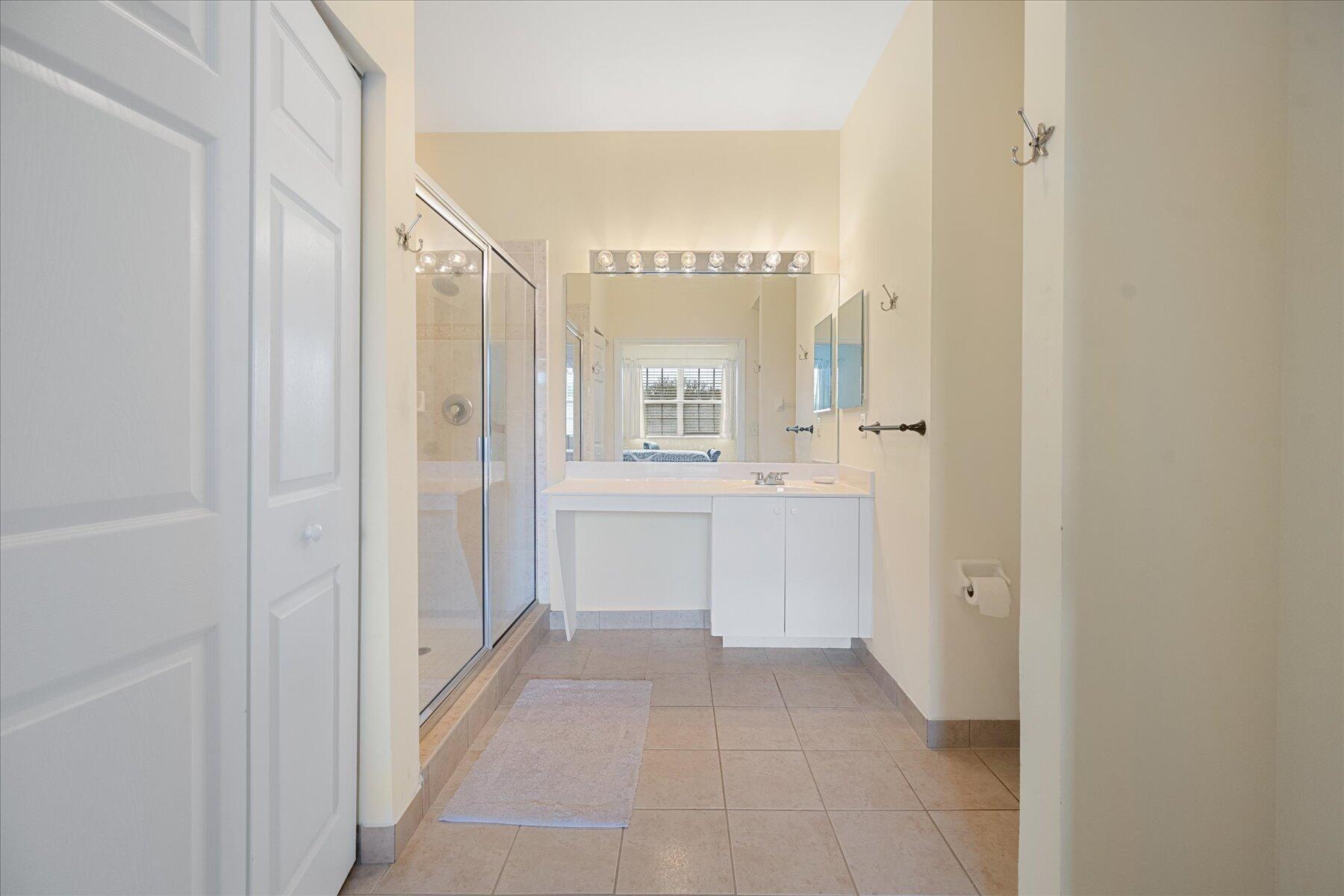 112 Lighthouse Circle, Unit G Tequesta, FL 33469 - Photo 17 of 27 a view of a hallway with wooden floor and a bathroom