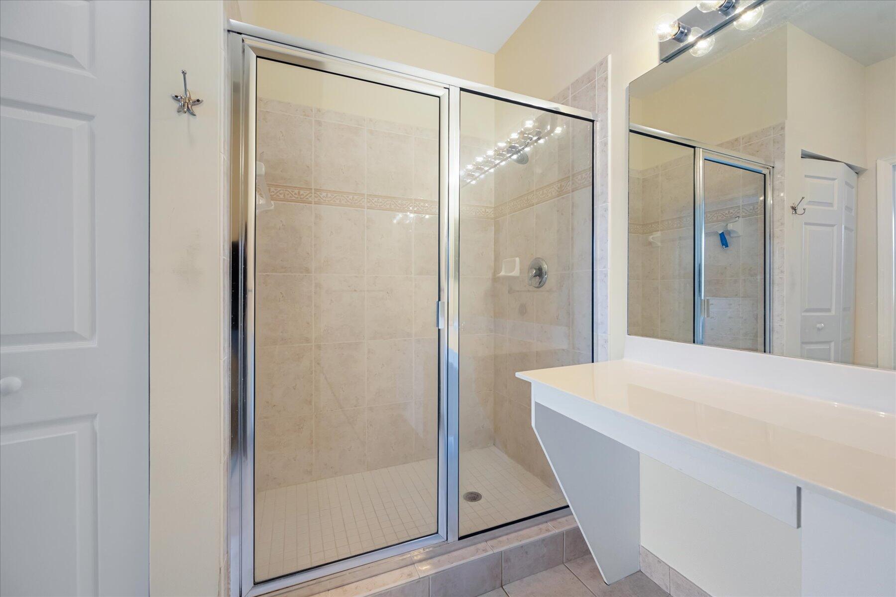 112 Lighthouse Circle, Unit G Tequesta, FL 33469 - Photo 18 of 27 a bathroom with a shower and a sink