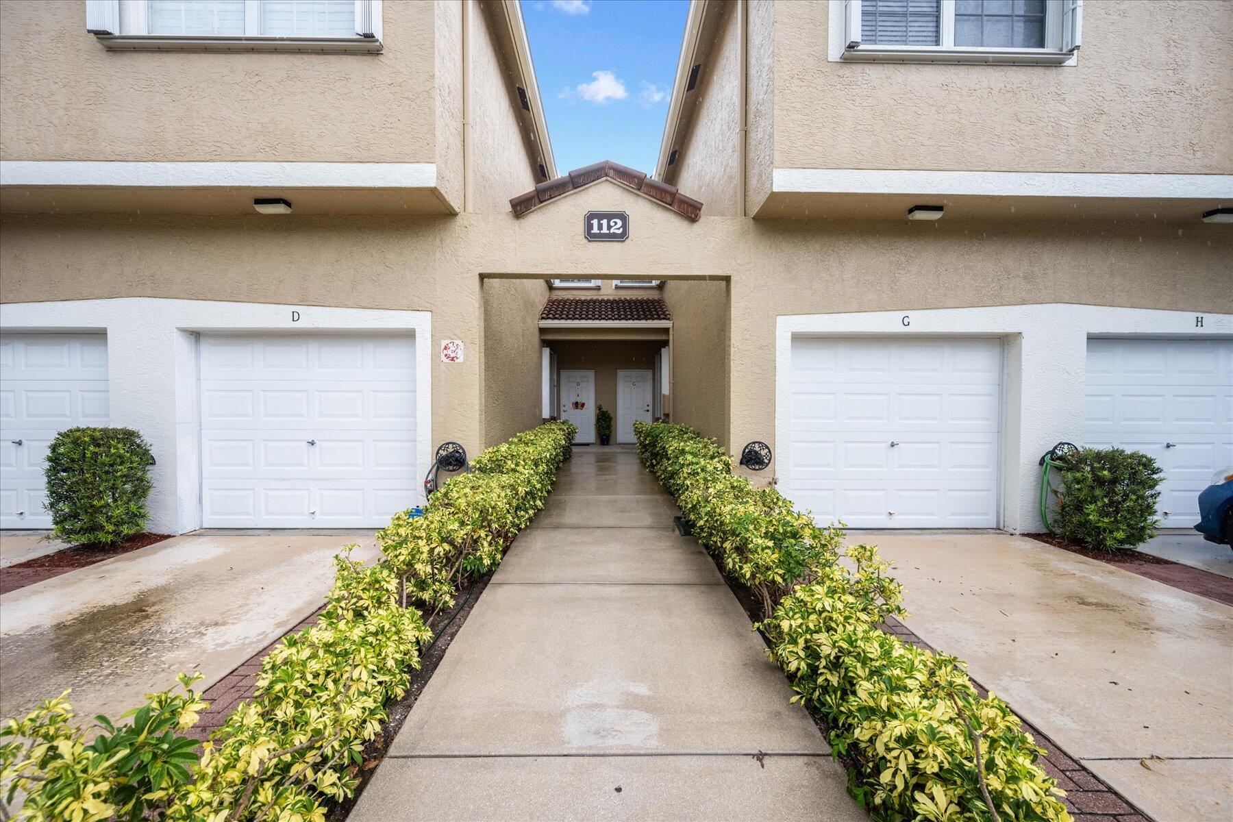 112 Lighthouse Circle, Unit G Tequesta, FL 33469 - Photo 2 of 27 a front view of a house with garden