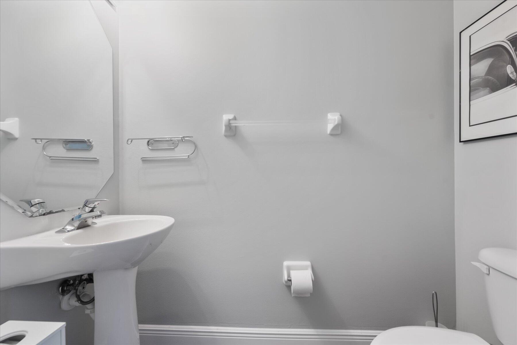 112 Lighthouse Circle, Unit G Tequesta, FL 33469 - Photo 27 of 27 a bathroom with a sink a mirror and a toilet