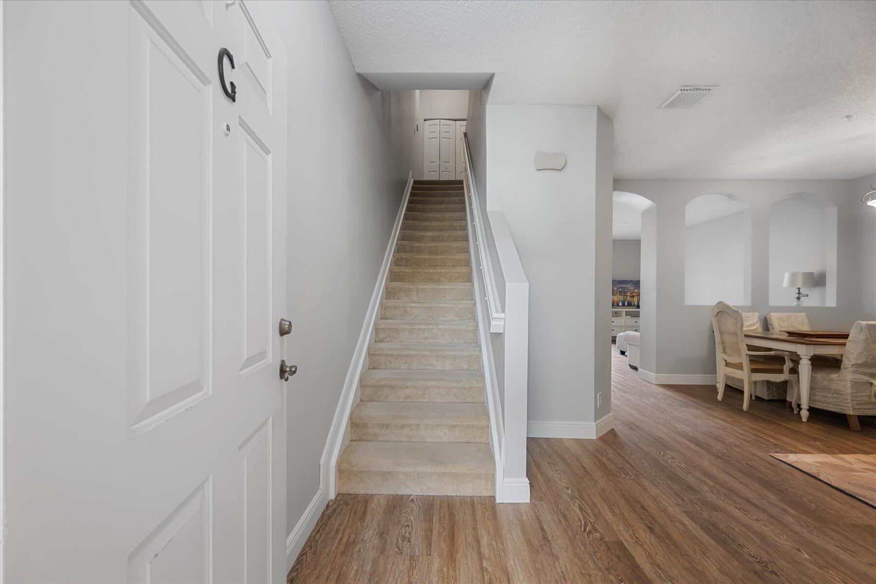 112 Lighthouse Circle, Unit G Tequesta, FL 33469 - Photo 3 of 27 a view of a hallway with wooden floor and furniture