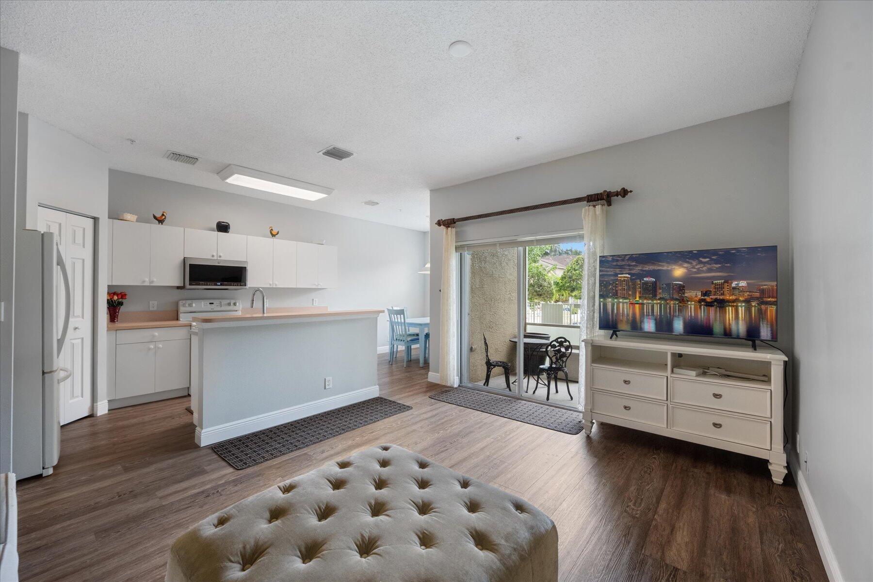 112 Lighthouse Circle, Unit G Tequesta, FL 33469 - Photo 7 of 27 a kitchen with stainless steel appliances kitchen island granite countertop a refrigerator and a stove top oven