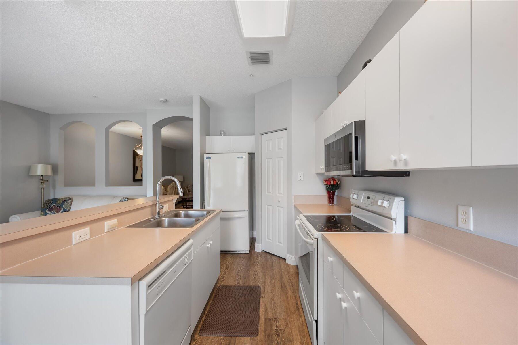 112 Lighthouse Circle, Unit G Tequesta, FL 33469 - Photo 9 of 27 a kitchen with a sink and white cabinets