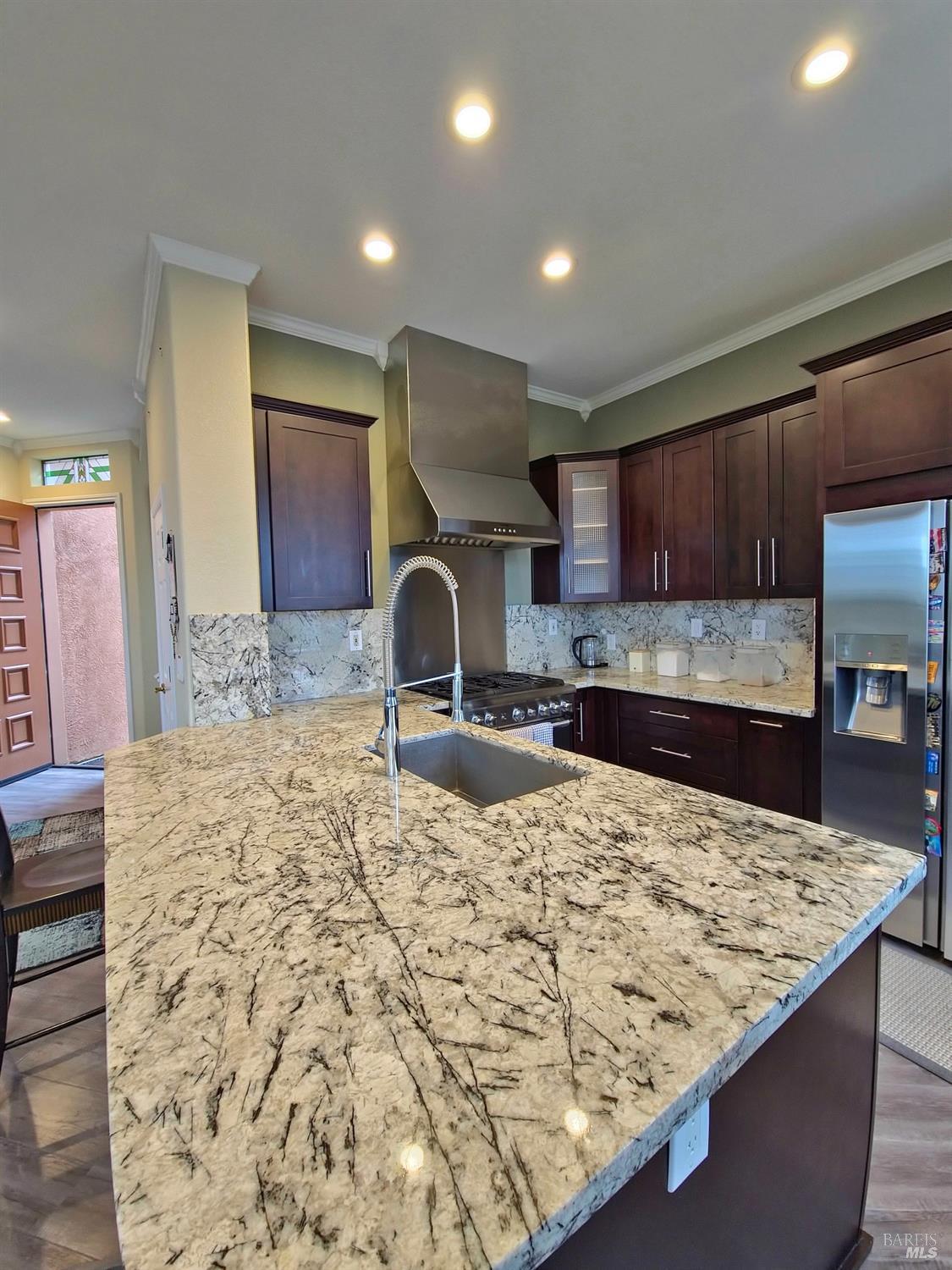 a kitchen with kitchen island granite countertop a sink and a wooden cabinets