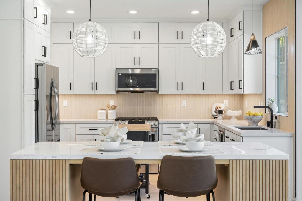 1653 Reflection Street San Marcos, CA 92078 - Photo 17 of 68 a kitchen with stainless steel appliances granite countertop a sink refrigerator stove and microwave
