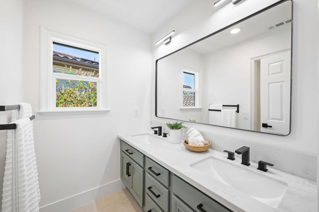 1653 Reflection Street San Marcos, CA 92078 - Photo 46 of 68 a bathroom with a sink a vanity and a mirror