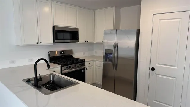 a kitchen with stainless steel appliances granite countertop a sink stove and refrigerator