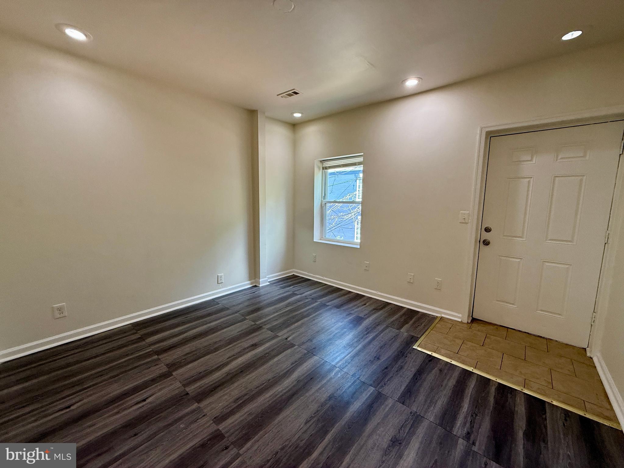 1908 M Street Northeast Washington, DC 20002 - Photo 12 of 20 a view of an empty room with wooden floor and a window