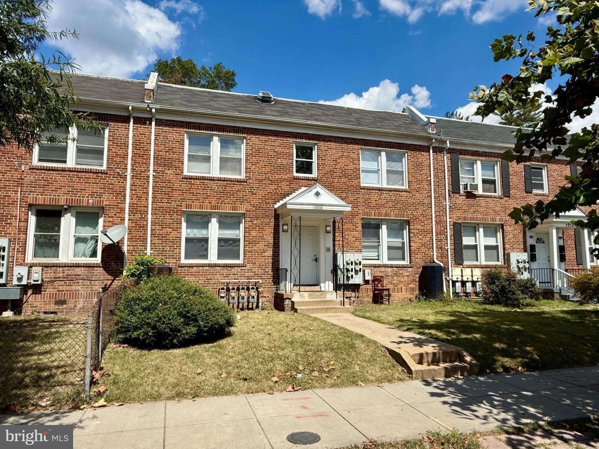 1908 M Street Northeast Washington, DC 20002 - Photo 2 of 20 a front view of a residential apartment building with a yard