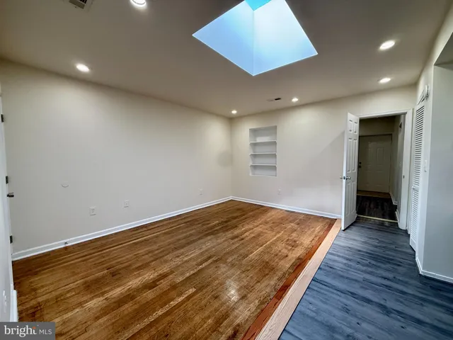 an empty room with wooden floor and closet