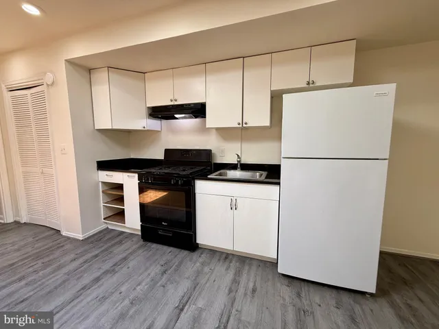 a kitchen with a refrigerator and a stove top oven