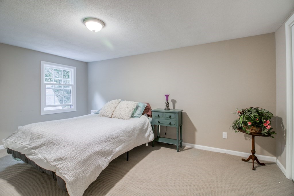 27 Thayer Road Monson, MA 01057 - Photo 26 of 39 a bedroom with a bed and a chandelier