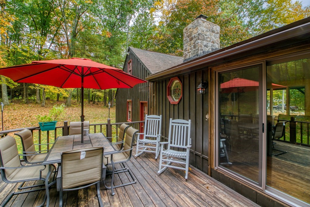 27 Thayer Road Monson, MA 01057 - Photo 33 of 39 a view of a patio with a table and chairs under an umbrella with barbeque grill and wooden floor