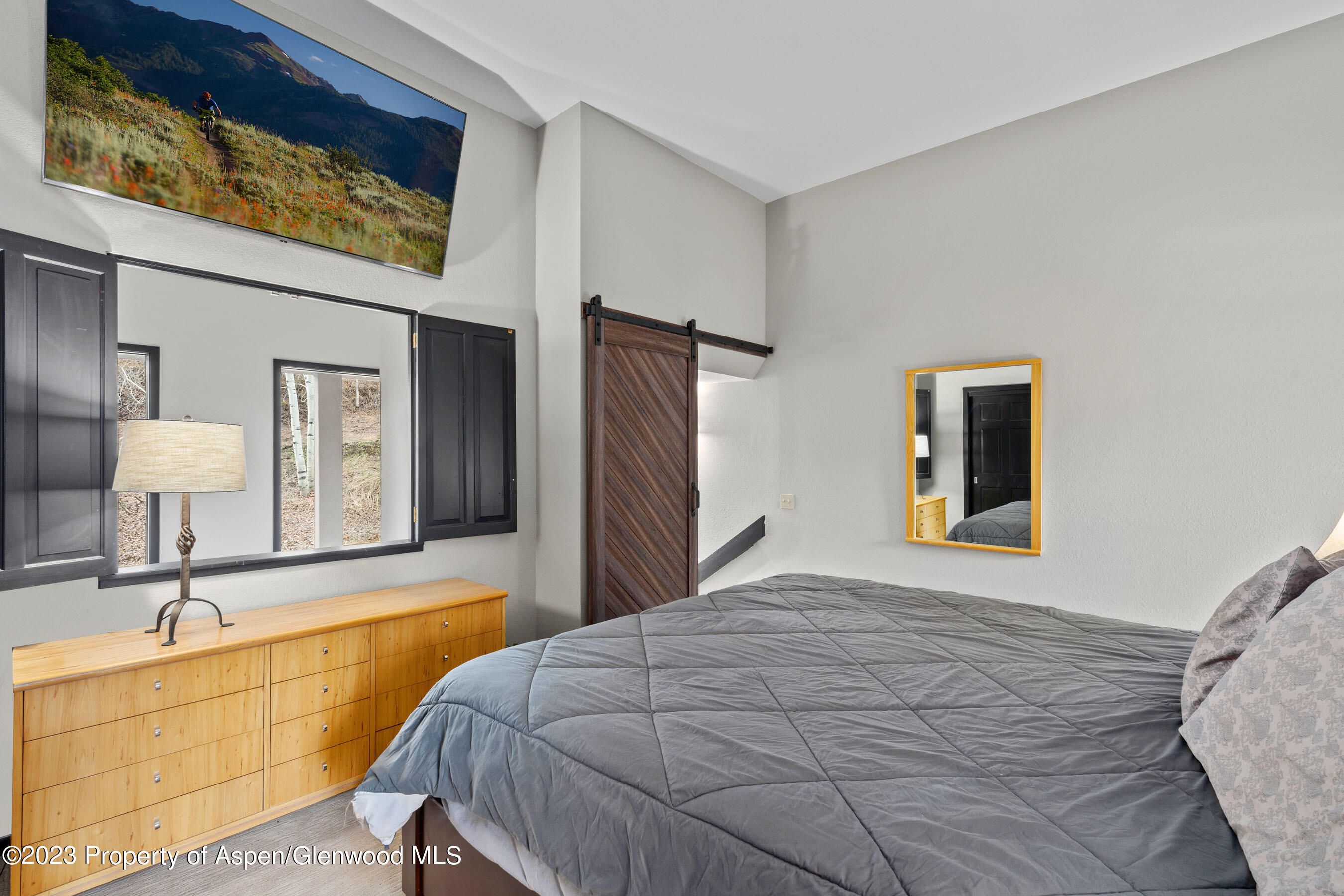 425 Wood Road, Unit 6 Snowmass Village, CO 81615 - Photo 17 of 29 a bedroom with a bed and a lamp on dresser