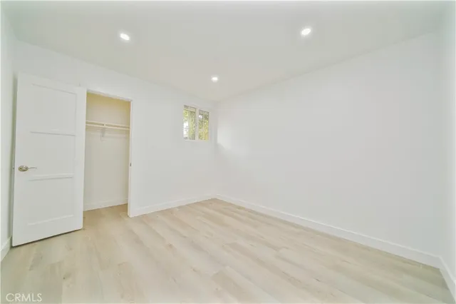 an empty room with a wooden door and a window