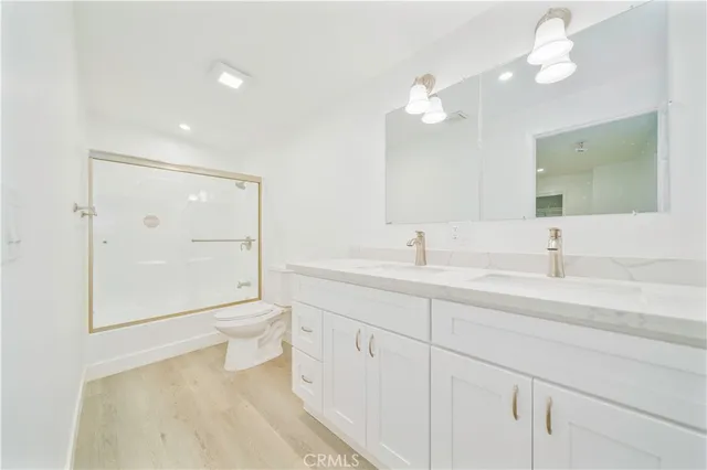 a bathroom with a toilet a sink and a large mirror