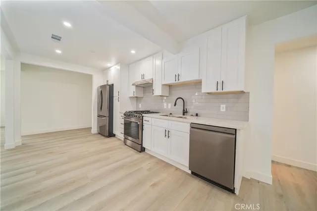 a kitchen with white cabinets and white appliances