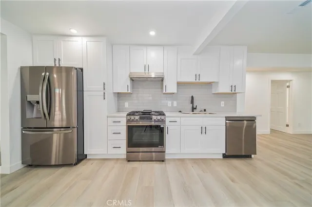 a kitchen with a refrigerator stove and wooden cabinets