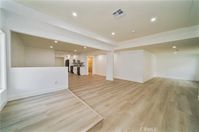 a view of empty room with wooden floor