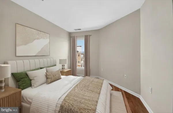 a bedroom with a bed and a painting on the wall