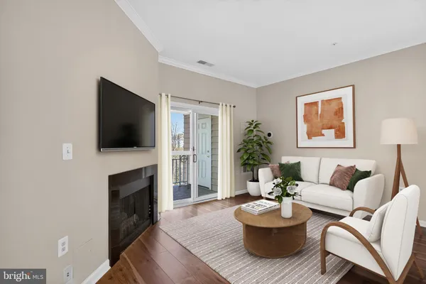 a living room with furniture a flat screen tv and a fireplace